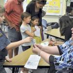 Kayden Disinski, a Helen Haller Elementary fourth-grader, introduces himself to Laura Lorentzen during Back to School Night to earn a stamp on his passport. Lorentzen is the new music teacher at Helen Haller Elementary, after Steve Hall retired at the end of the 2016-17 school year. Photo by Patsene Dashiell
