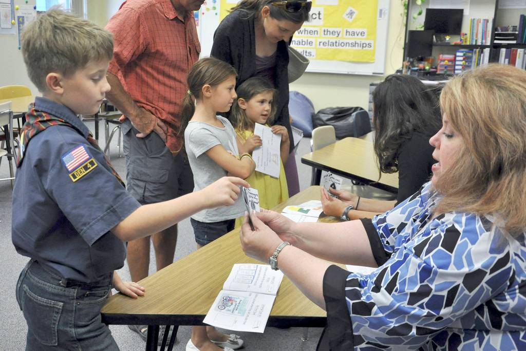 Kayden Disinski, a Helen Haller Elementary fourth-grader, introduces himself to Laura Lorentzen during Back to School Night to earn a stamp on his passport. Lorentzen is the new music teacher at Helen Haller Elementary, after Steve Hall retired at the end of the 2016-17 school year. Photo by Patsene Dashiell