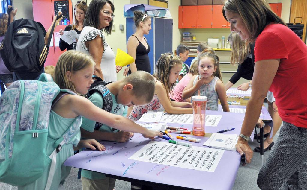 Lucy and Ryan Spelker, fourth-grade students at Helen Haller Elementary School, sign the Kids at Hope Pledge as Haller principal Becky Stanton looks on. The pledge states that &ldquo;All children are capable of success, no exceptions!&rdquo; Photo by Patsene Dashiell