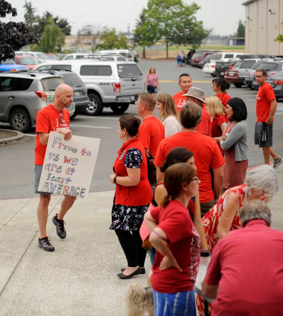 Sequim Middle School teacher Dave McInnes, left, and fellow teachers and school advocates gather outside the Sequim School District boardroom on Sept. 5. Sequim Gazette photo by Michael Dashiell