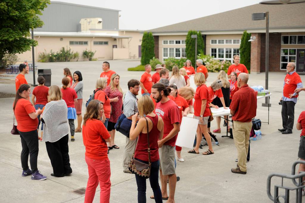 Clad in red, Sequim School District staffers and advocates gather outside the Sequim School District boardroom on Sept. 5. Sequim Gazette photo by Michael Dashiell