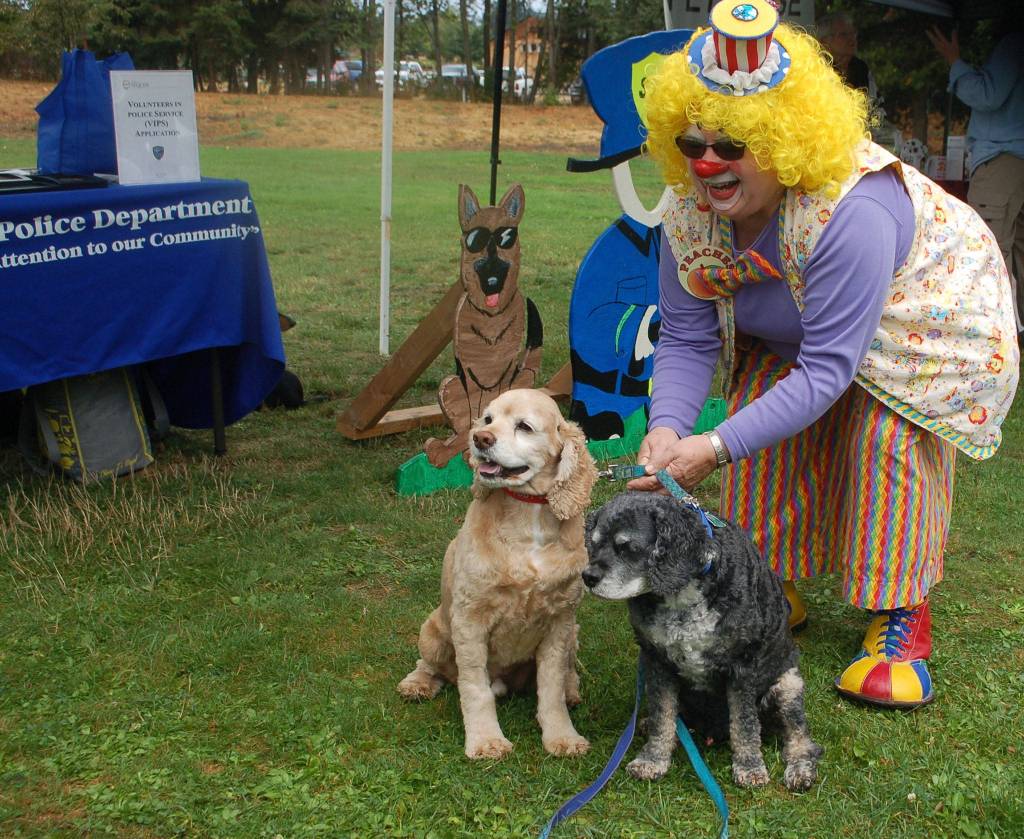 Naomi Foley, also known as &ldquo;Peaches&rdquo; the clown takes a photo with two cockapoos Toby, left, and Barkley at the Sequim Dog Park&rsquo;s 10th Anniversary celebration at Carrie Blake Park. Sequim Gazette photo by Erin Hawkins
