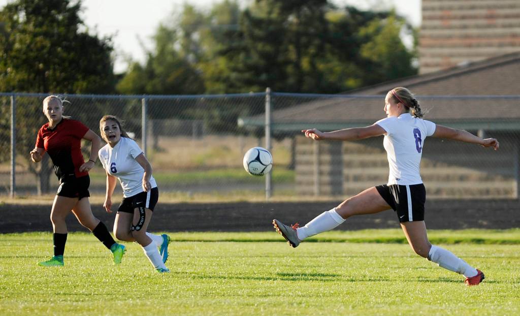 Sequim&rsquo;s Olivia Hare, right, passes to a teammate as fellow Wolf Miranda Williams (6) looks on. Sequim Gazette photo by Michael Dashiell