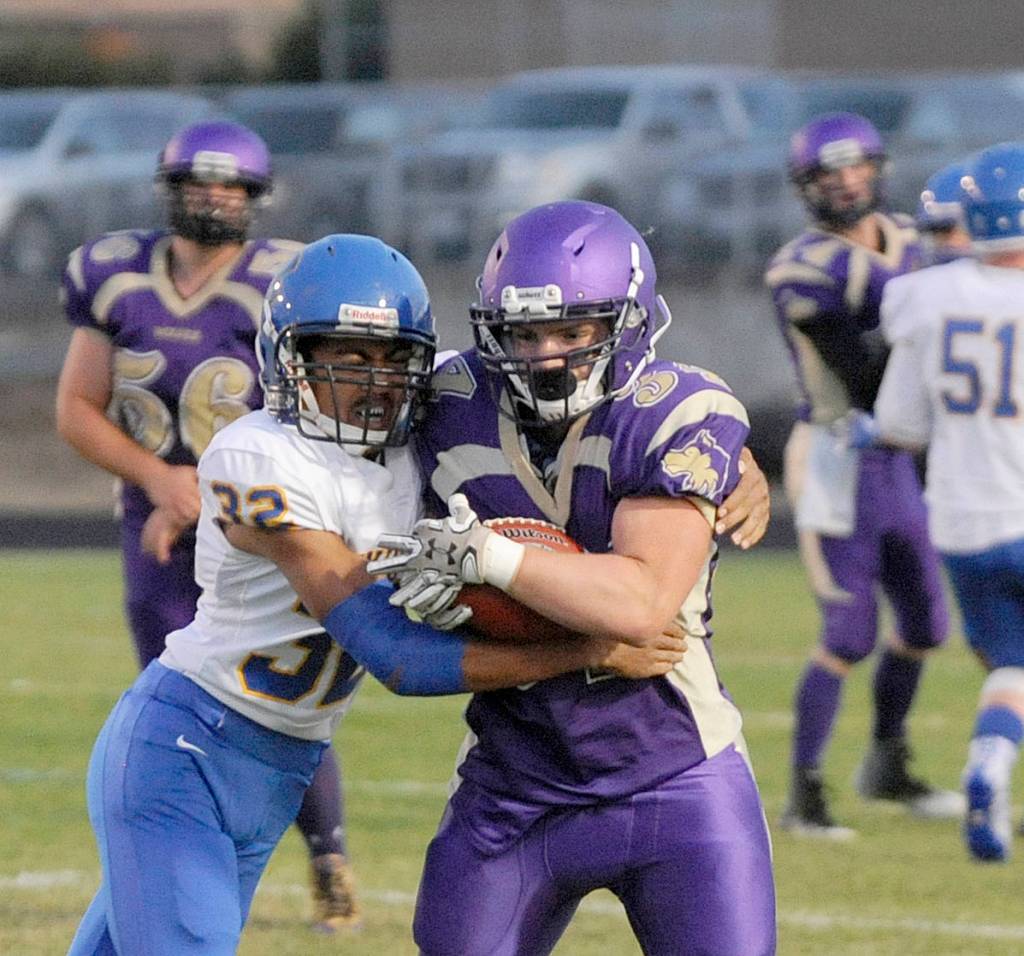 Bremerton&rsquo;s Kaipo Retome, left, wraps up Sequim running back Tyler Conn after the Sequim back catches a screen pass in the first quarter. Sequim Gazette photo by Michael Dashiell