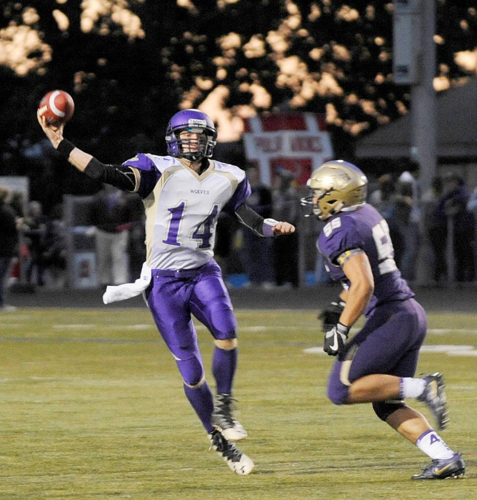 Sequim quarterback Riley Cowan, left, looks for a receiver as North Kitsap&rsquo;s Connor Westby provides pressure. Westby sacked Cowan twice in NK&rsquo;s 42-0 win on Sept. 29 in Poulsbo. Sequim Gazette photo by Michael Dashiell