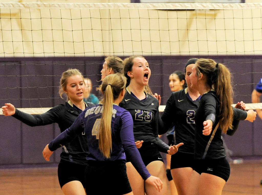 Sequim&rsquo;s Arlene Law (center) celebrates another Sequim point in a 3-1 win over the visiting Olympic Trojans on Oct. 5. Law had 13 kills and two blocks in the win. Sequim Gazette photo by Matthew Nash