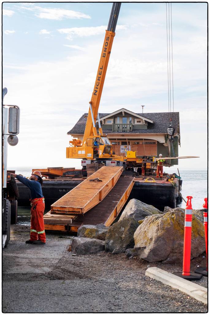 Crews from Nickel Bro. carefully unload Jim and Diane Luomas&rsquo; craftsman home off a barge onto Cline Spit. Photo by Bob Lampert