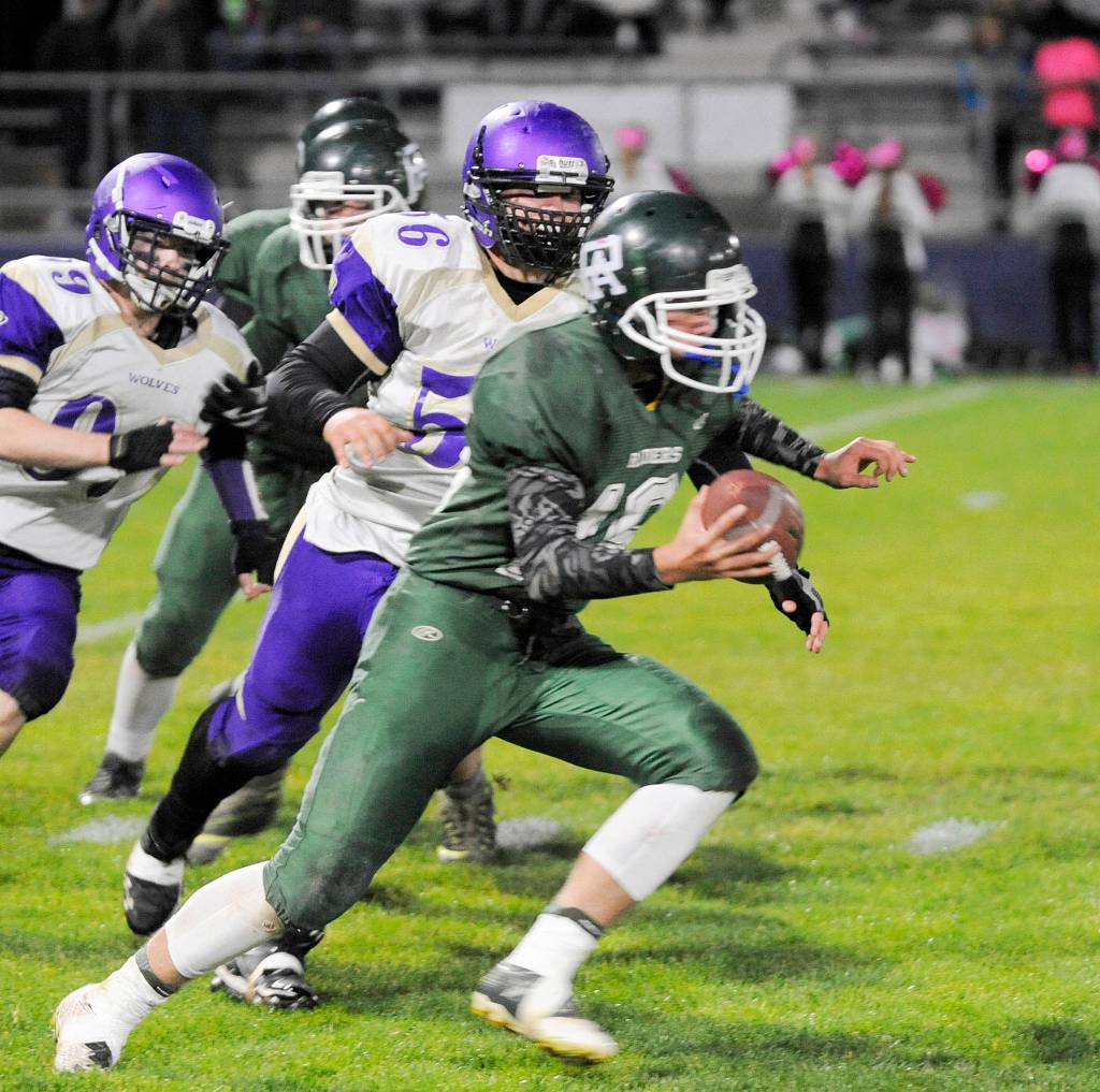 Sequim&rsquo;s Mason Larsen (56) and Ben Cowan (99) pursue Port Angeles quarterback Easton Joslin in Sequim&rsquo;s 29-14 win on Oct. 20. Sequim Gazette photo by Michael Dashiell