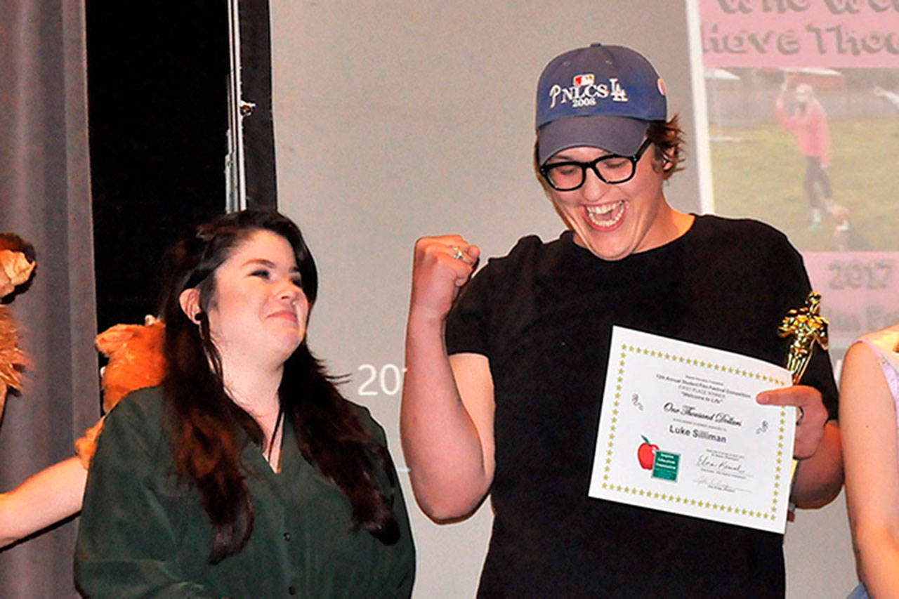 Luke Silliman celebrates winning the audience choice award, or the Elkie, at the Sequim Education Foundation&rsquo;s Student Film Festival on April 21, in Sequim High School with his friend Emma Gallaher. Their film &ldquo;Welcome to Life&rdquo; also won first place and a $1,000 scholarship. Silliman was recently in an accident where he fell from a bridge near his college in Chicago. Sequim Gazette file photo by Matthew Nash