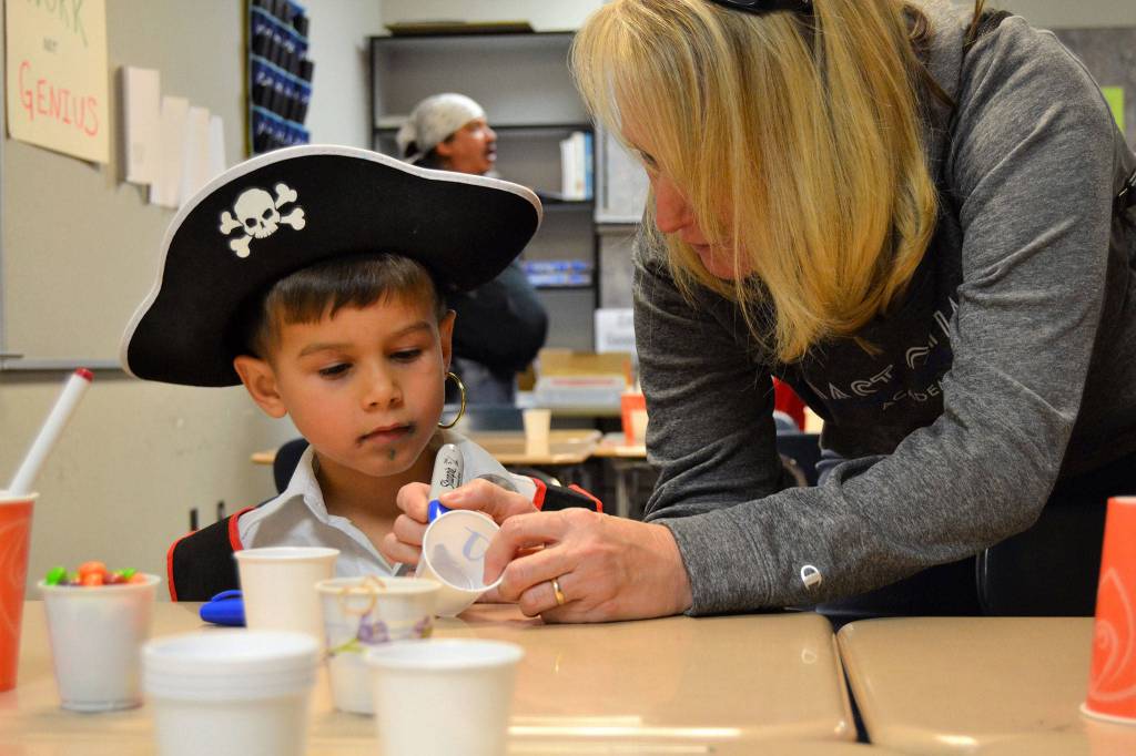 Jackson Moroles, 3, makes a candy shaker with his grandma Christy Moroles at Sequim High School&rsquo;s Haunted Hallways event. School clubs and classes led activities in each room, such as the band hosting the chance to make candy shakers.