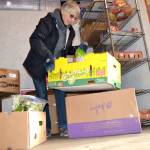Isabelle Dunlop, a volunteer at the Sequim Food Bank, readies produce for visitors prior to a distribution day. Food bank leaders plan to expand operations in some capacity in 2018 at a house directly west of the property.