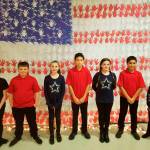 Boys & Girls Club members, from left, Alexandra Treece, Zac Bell, Taylor Heyting, Titus Liggins, Kaylee Straling, Saul Williams, and Sophia Treece stand before a large display at the auction supporting Sequim and Port Angeles clubs on Nov. 11. Submitted photo