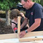 John Brygider helps Kaia McCarter, a girl scout with Troop 43870, build a bench for a room in the Sequim Police Department specifically for children.