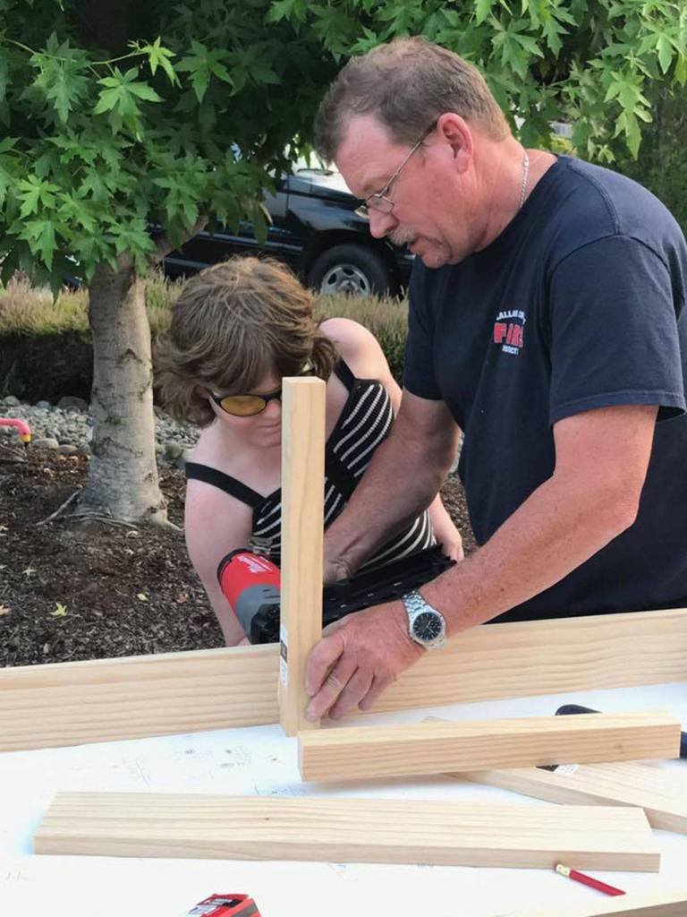John Brygider helps Kaia McCarter, a girl scout with Troop 43870, build a bench for a room in the Sequim Police Department specifically for children.