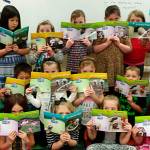 Top, Christine MacDougall-Danielsons first grade class hold books they received through Beta Nu Chapter of Delta Kappa Gamma. Below, fourth graders, from left, James Brown, Korey Apley, Javelin Rouque, Shelby Haskins, Paige Reed, Ryan Spelker, and Madysyn Salazar hold up newspapers that they read every week in Patrick Carons class. Submitted photos