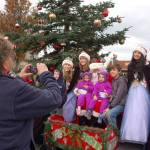 Gerri Cooley of Sequim takes photos of her grandchildren Carson, 5, Audrey and Addison, 2, and Cody, 11, as they sit with Santa Claus and Sequim Irrigation Festival Royalty at Centennial Place in Sequim. Sequim Gazette photo by Erin Hawkins