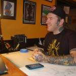 Professional tattoo artist Keith Dulin discusses tattoo design concepts with a client on the officially opening of his business Black Reign Tattoo on Nov. 25 in Sequim. Sequim Gazette photo by Erin Hawkins