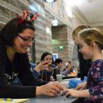 Ava Jordan, 5, makes a macaroni necklace with Candace Mangold of Olympic Peninsula Macaroni Kid at the annual Breakfast with Santa event in Sequim Middle School on Dec. 2. Sequim Gazette photo by Matthew Nash