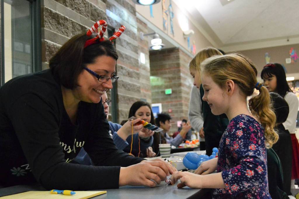 Ava Jordan, 5, makes a macaroni necklace with Candace Mangold of Olympic Peninsula Macaroni Kid at the annual Breakfast with Santa event in Sequim Middle School on Dec. 2. Sequim Gazette photo by Matthew Nash