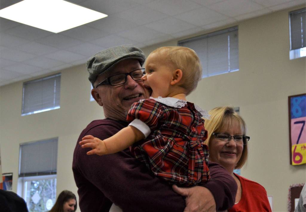 Mickey Aughtry of Sequim holds his granddaughter Maddie Aughtry, 1, after she got her photo taken with Mr. and Mrs. Santa Claus on Dec. 2. Sequim Gazette photo by Matthew Nash