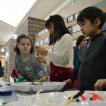 Kora Gilliam, and Kyla and Mason Blake of Sequim make macaroni necklaces at the Olympic Peninsula Macaroni Kid booth at the Breakfast with Santa event. Sequim Gazette photo by Matthew Nash