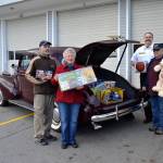 Members of the Sequim Valley Car Club, from left, Ralph Elston, Diane McIntosh, Fire Chief Ben Andrews with Clallam County Fire District 3, and David McIntosh stand with toys that filled Elstons 1939 Buick for Toys for Sequim Kids. Sequim Gazette photo by Matthew Nash