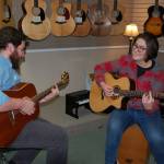 Sequim High School sophomore Kyah Fukunaga (right) tries out her new acoustic-electric guitar she received during the schools Winter Wishes assembly on Dec. 13. She practices with Joyful Noise Music Center instructor John Mangiameli (left) at the center during a music lesson. Sequm Gazette photo by Erin Hawkins