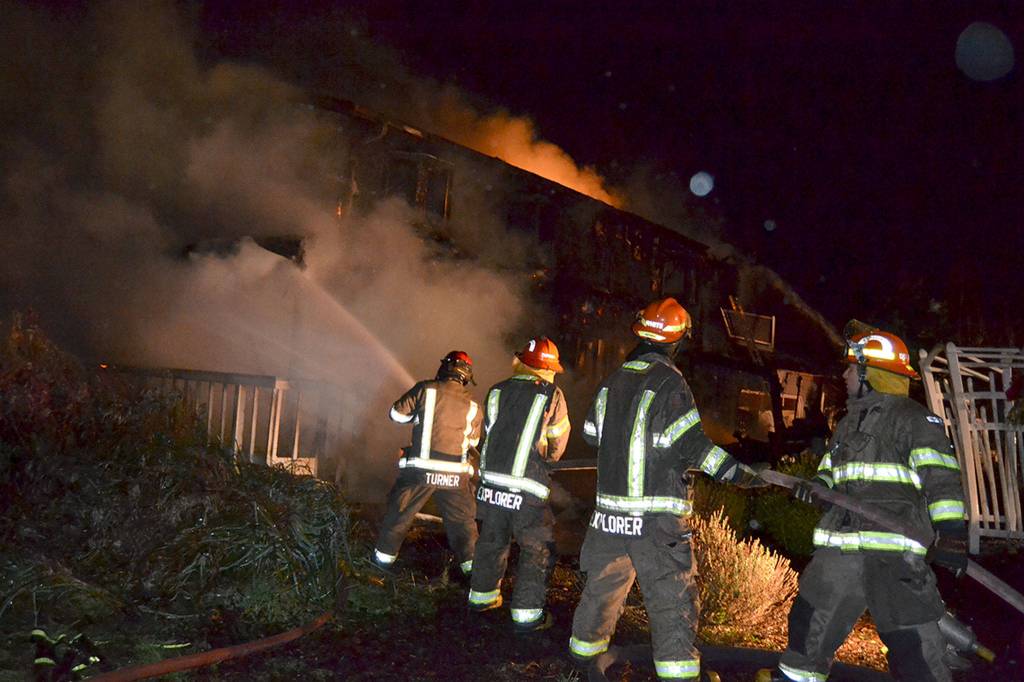 Captain Chris Turner with Clallam County Fire District 3 leads Explorer Scouts with Post 1003 in fighting a house fire on Dec. 18 on 3 Crabs Road. Firefighters reported to the scene around 8:30 p.m. and extinguished it around midnight. Sequim Gazette photo by Matthew Nash