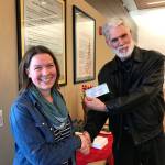 Emily Sly, Sequim Librarys branch manager, accepts a $27,000 check on Jan. 16 inside the Sequim Civic Center from Martin Shaw, treasurer for the Friends of Sequim Library. The donation comes from the Friends groups monthly book sale and permanent sale inside the Sequim Library. Funds support the librarys entire program schedule, Sly said. Submitted photo