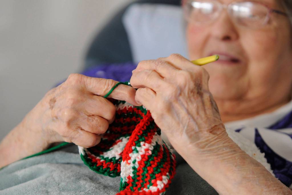 Phyllis Peashka says she taught herself to crochet. She figures she makes at least one hat, scarf or potholder per day. My hands cramp up, but I keep going. Sequim Gazette photo by Michael Dashiell