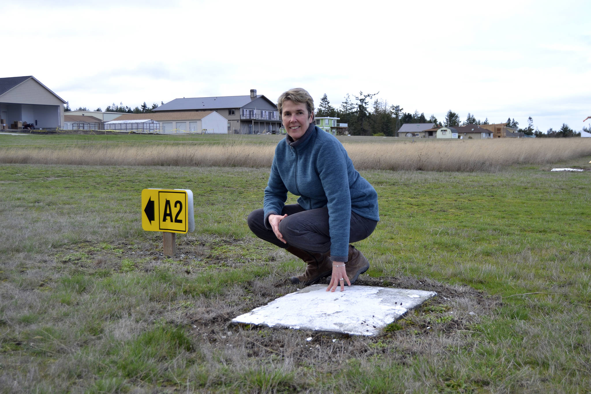 Kaye Gagnon, volunteer for the Diamond Point Airport Association, stands near one of the four corners of the Diamond Point Airports helipad. Airport Association members seek up to $8,000 to support paving the helipad to make it safer for airlifts. Sequim Gazette photo by Matthew Nash