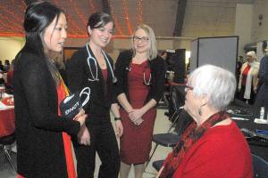 Keith Thorpe/Peninsula Daily News Olympic Medical Center workers, from left, exercise specialist Sherry Xiong, nuclear medical technician Brittany Payseno and cardiac sonographer Kerie Swegle talk with guest Dee Kurtz before the start of Fridays 11th annual Red, Set, Go! Heart Luncheon at Vern Burton Community Center in Port Angeles. The charity event, hosted by the Jamestown S’Klallam Tribe, benefitted the Olympic Medical Center Foundation with goal of raising funds toward the purchase of a nuclear camera for cardiac stress testing.