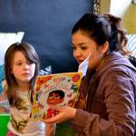 At left, Sequim High Schooler Stephanie Lemus reads to kindergartner Lyric Marsh in Stephanie Grotzke-Nashs class a story based on the movie Coco.