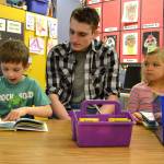 First grader Bryant Lawson reads a Dr. Seuss tale to Sequim High Schooler Jacob Myers and Bryants classmate Pepper Jones in Ione Marcys class on March 2.