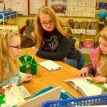Sequim High Schooler Alyssa Rothganger, center, sits in on a classic Dr. Seuss tale in Bettina Hoesels first grade class at Helen Haller Elementary as Chloe Seymour reads and Trinity Devlin listens in. Sequim Gazette photos by Matthew Nash