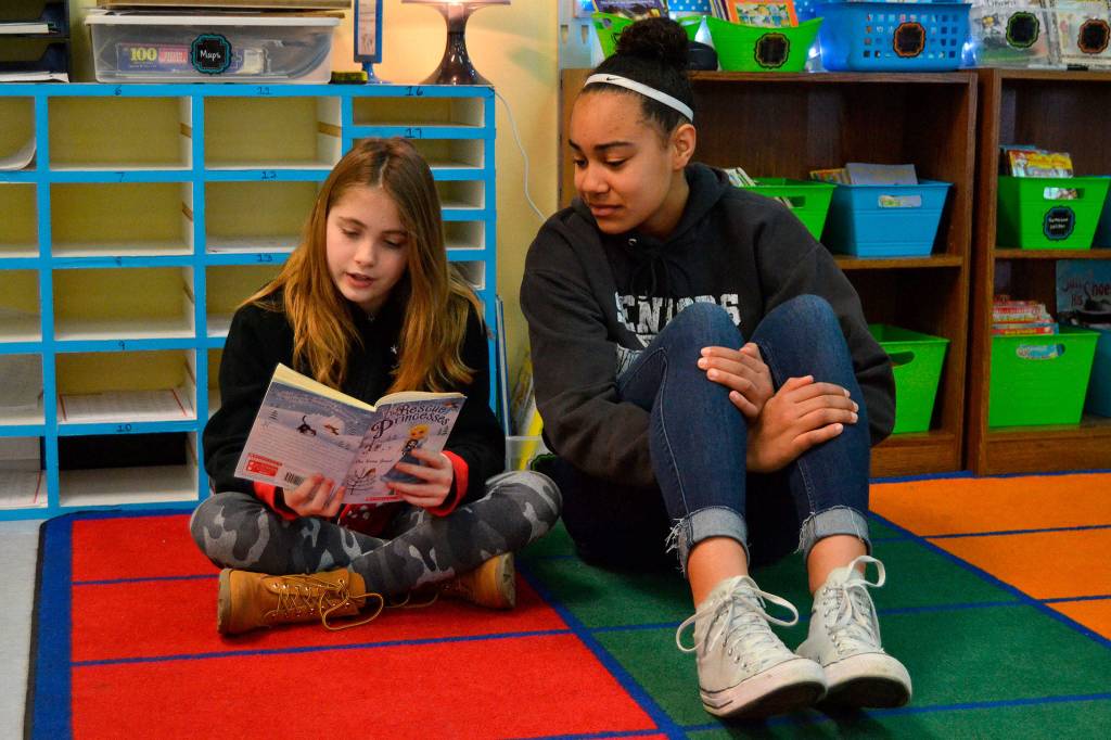 Third grader Glenna Krieger in Emily Ellefsons class reads to Sequim High School Jayla Julmist at Helen Haller Elementary for Read Across America Day. Sequim schools have participated in the event for a number of years. Sequim Gazette photo by Matthew Nash