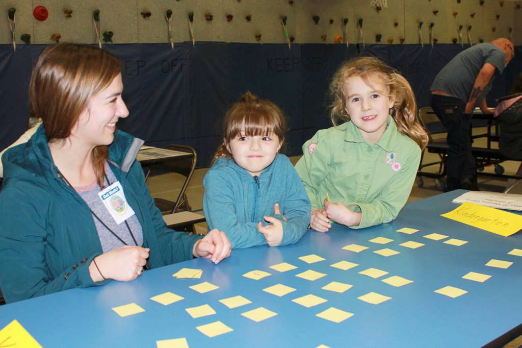 Teacher Kelli Mishko joins students Stella Yednick and Susie Updike at the schools Math Night on March 22. Photos by Darcy Lamb