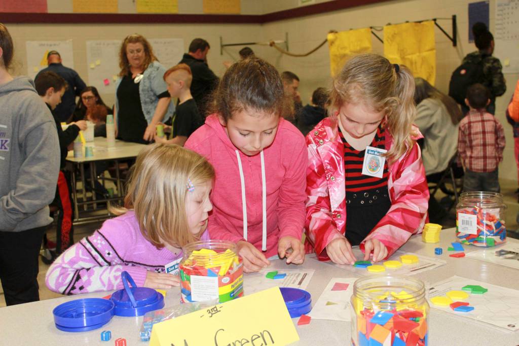 Students Xillion Stone, Rhyen Badasha and Lyra Reuther try their hand at math games at Greywolf Elementary Schools Math Night on March 22.