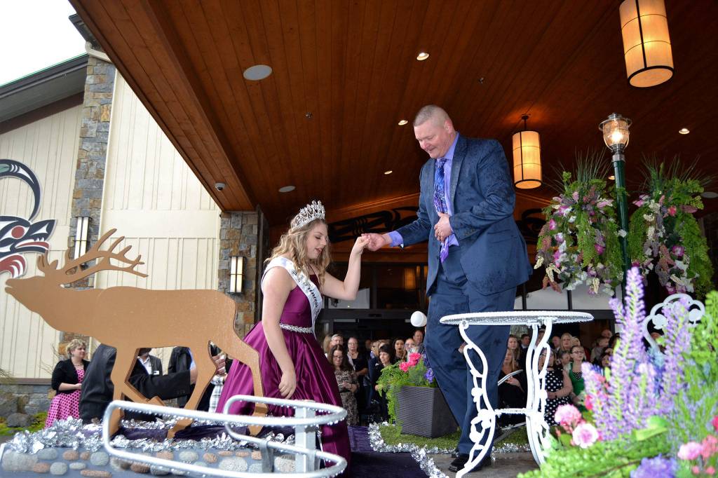 Kevin Kapetan helps Princess Gracelyn Hurdlow to her place on the Sequim Irrigation Festival royalty float on March 24. Sequim Gazette photo by Matthew Nash