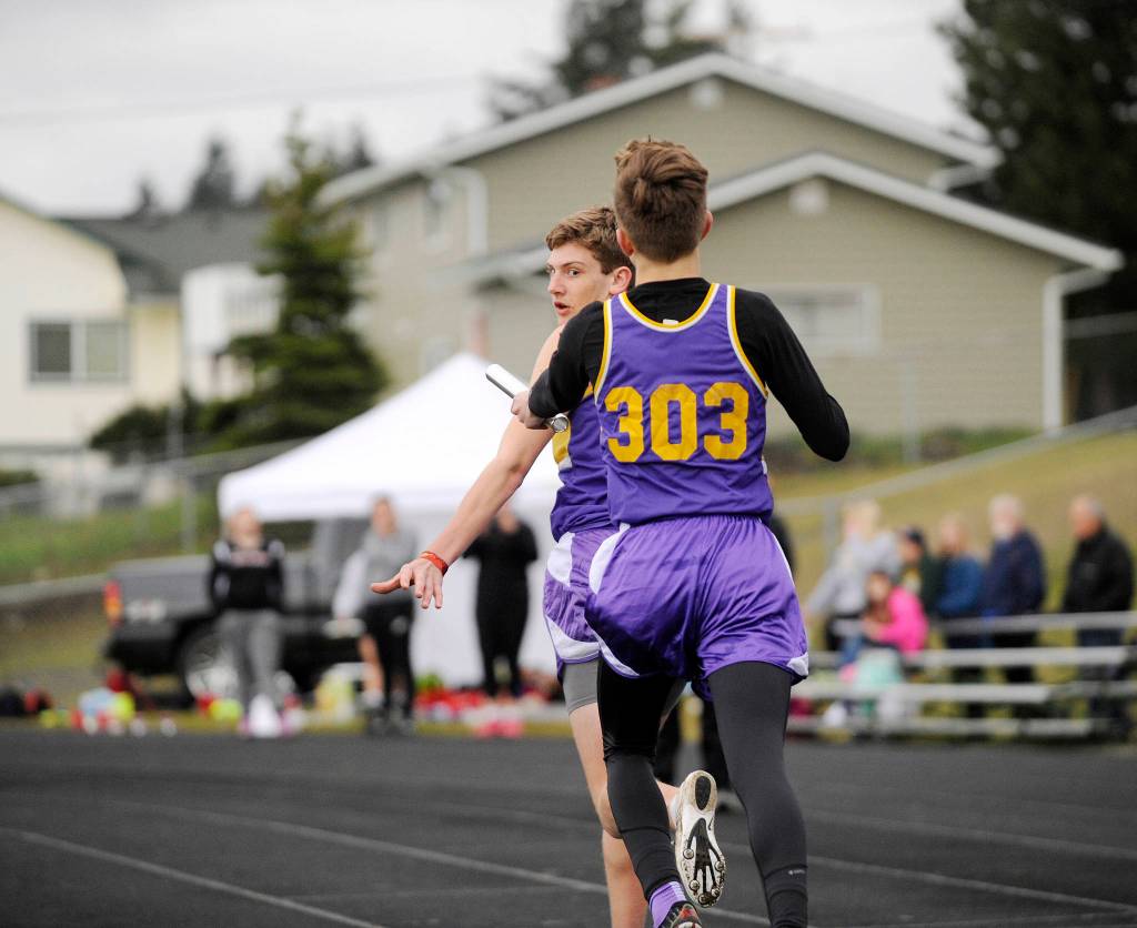 Fischer Jensen awaits a baton handoff from teammate Jakob Pyeatt in the 4x400 relay at last weeks Flying A Retro track and field meet in Port Angeles. Sequims A and B relay teams took first and second as the Wolves dominated the meets boys division. Sequim Gazette photo by Michael Dashiell