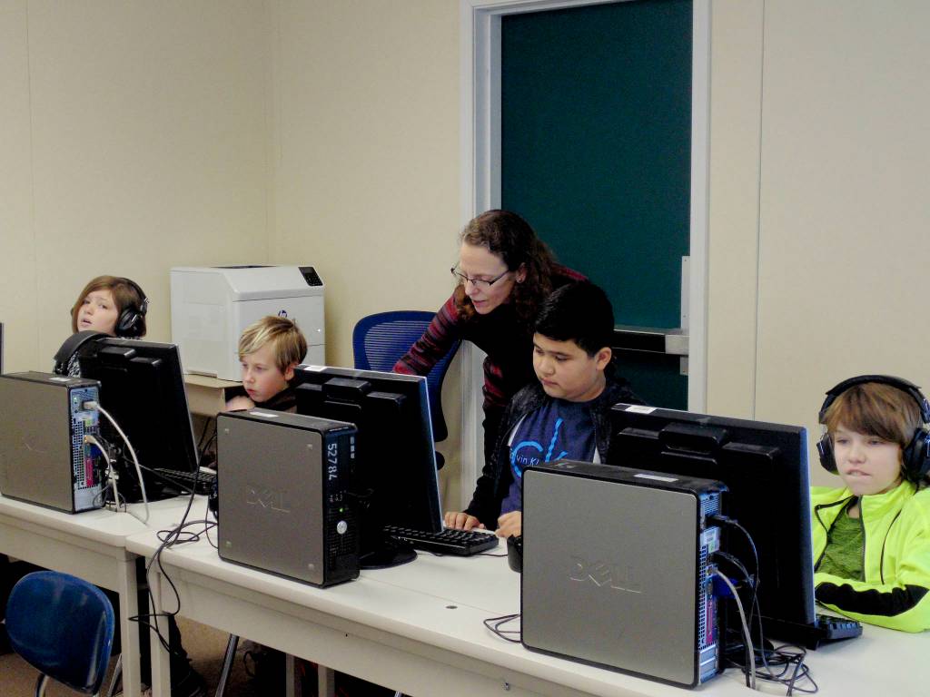 Betsy Smith (center), Helen Haller Elementary School reading specialist, works with (from left) Amara Osmer, Hurley Ware, Betsy Smith, Adrian Villicana, Hurley Ware, students from Sue Carons class. A community education grant from Beta Nu Chapter of Delta Kappa Gamma helped Smith purchase Read Naturally Live, an online fluency reading program. Submitted photo