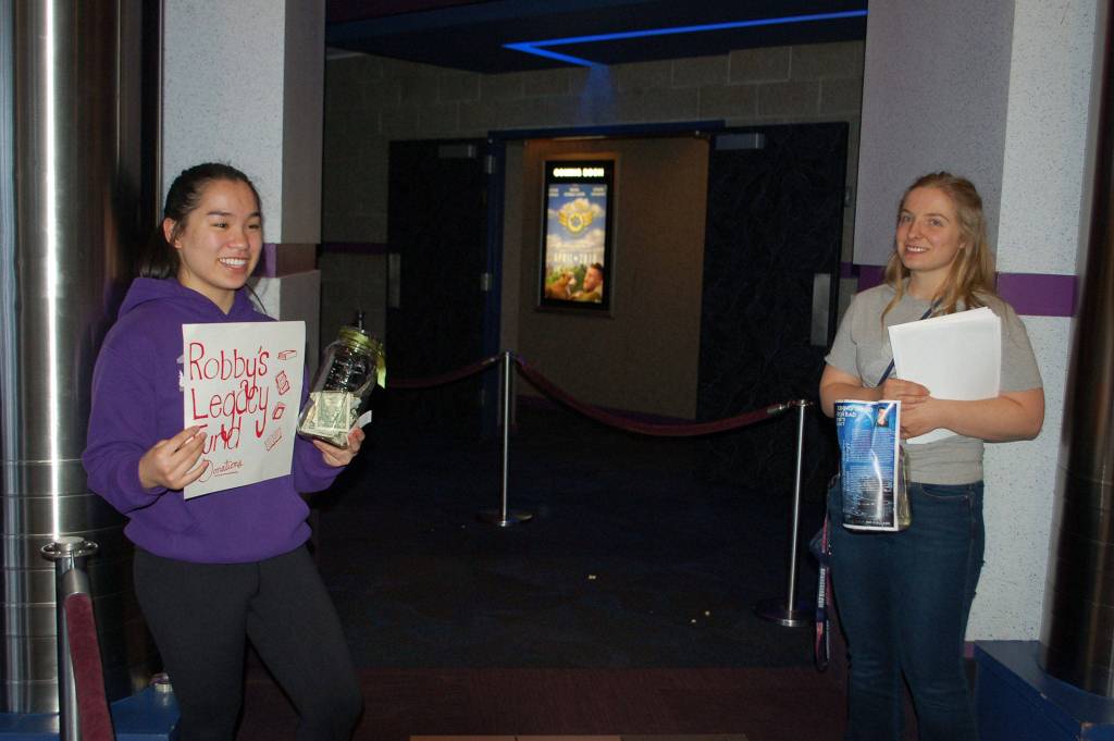 Sequim High School sophomore Lesae Pfeffer, left, and senior class president Anabelle Armstrong fundraise at Deer Park Cinema before the film Ready Player One in honor of Robby Streett and aim to raise money to to help the Sequim High Library purchase new furniture and help students indulge in one of Robbys favorite activities of reading. Sequim Gazette photo by Erin Hawkins