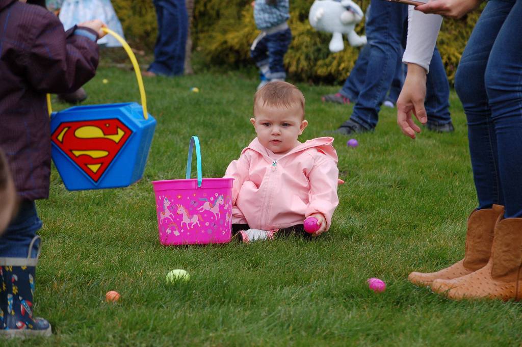 Mollie Lou Evans, 11 months, clutches an egg matching her pink basket at the Elks Lodge Easter egg hunt on March 31. Sequim Gazette photo by Erin Hawkins