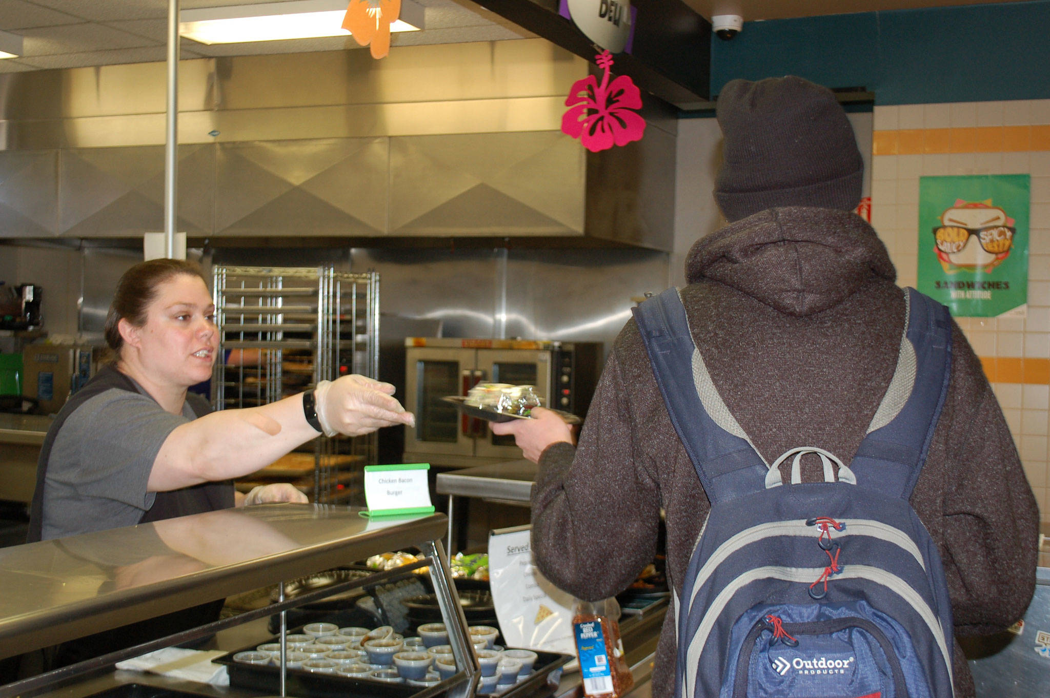 Corrine Wallen, lunch and breakfast staff at Sequim High School, serves a meal to a high school student during the schools lunch period. Sequim Gazette photo by Erin Hawkins