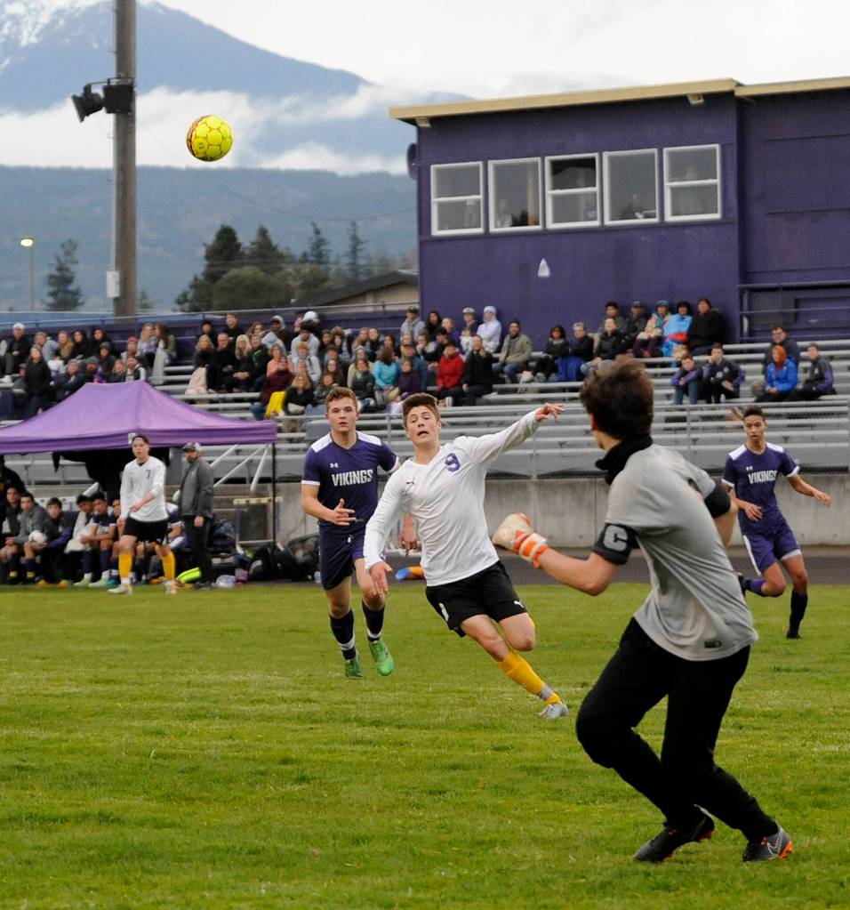 Sequims Adrian Funston tries to track down the ball deep in North Kitsap territory at Viking goalkeeper Matthew Tucker makes a play. Funston had two of the Wolves five scores in a 5-0 win Friday night. Sequim Gazette photo by Michael Dashiell