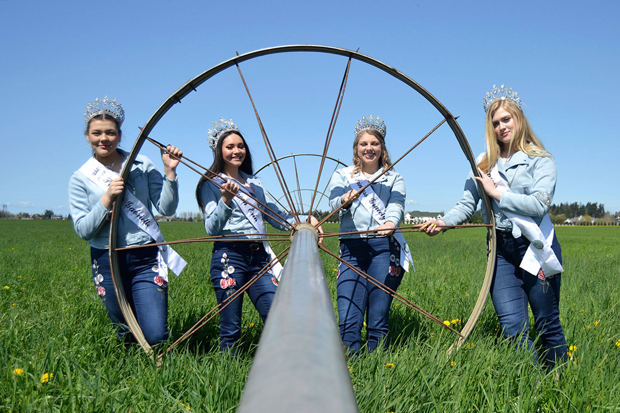 Sequim Irrigation Festival royalty, from left, Princess Gabi Simonson, Queen Erin Gordon, Princess Gracelyn Hurdlow, and Princess Eden Batson stand by a sprinkler on the Dick Family Farm during a photo shoot for the festivals programming. Sequim Gazette photo by Matthew Nash