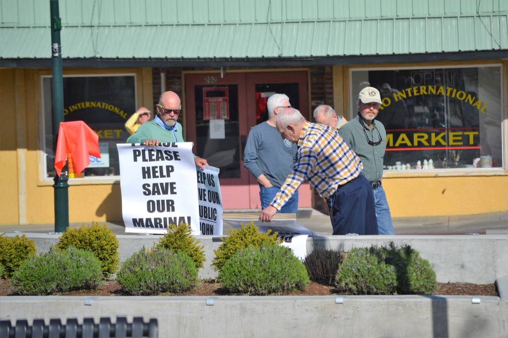 Community members gather with signs Please Please Help Save Our Marina! prior to the Sequim City Council meeting on April 23, where councilors approved a resolution to reaffirm the citys position that private marinas are not allowed. Sequim Gazette photos by Matthew Nash