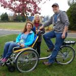 The Sequim Wheelers founder and Board president Nicole Lepping, foreground, and Board members Susan Hedding and Paul Muncey take its first wheelchair bike out for a spin near Bens Bikes in Sequim. Erin Hawkins/Olympic Peninsula News Group