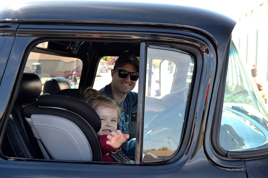 Nick Stewart and his daughter Kensington, 2 1/2, of Bonney Lake, ride as the last entry in the Hot Rods & Harleys Car Cruzz on May 12. Nick drove his dad Gary Stewarts 1957 Chevy truck while Gary drove the 1979 Chevy C10 along Washington Street to Walmart for the car show. Sequim Gazette photo by Matthew Nash