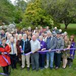 Priscilla Hudson, Sequim Prairie Garden Club member/historian, cuts the ribbon on May 16 to the refurbished fountain in Pioneer Memorial Park. Shes surrounded by dozens of community members including family members of the Lotzgesell family with Henry Lotzgesell donating a sizable amount in 1965 in honor of his wife Hazel to see the project come to fruition. Sequim Gazette photo by Matthew Nash